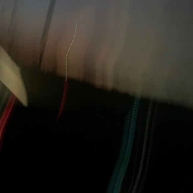 A close-up of a wire and a zipper with a dark background.