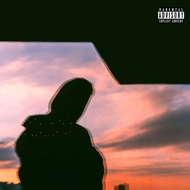 A silhouette of a person with a city skyline in the background during a colorful sunset sky.