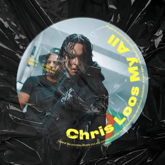 A vinyl record with artwork featuring two young men, one with dreadlocks and the other with dark hair. The record has yellow text around the center that says "Chris LOSI M. 21" and additional text about the record information.