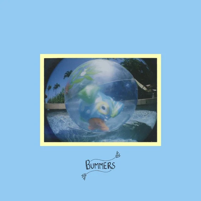 Album Cover called "Thighs" from the band Bummers. A colorful fish-shaped inflatable ball floating in water with a reflection of palm trees and blue sky.