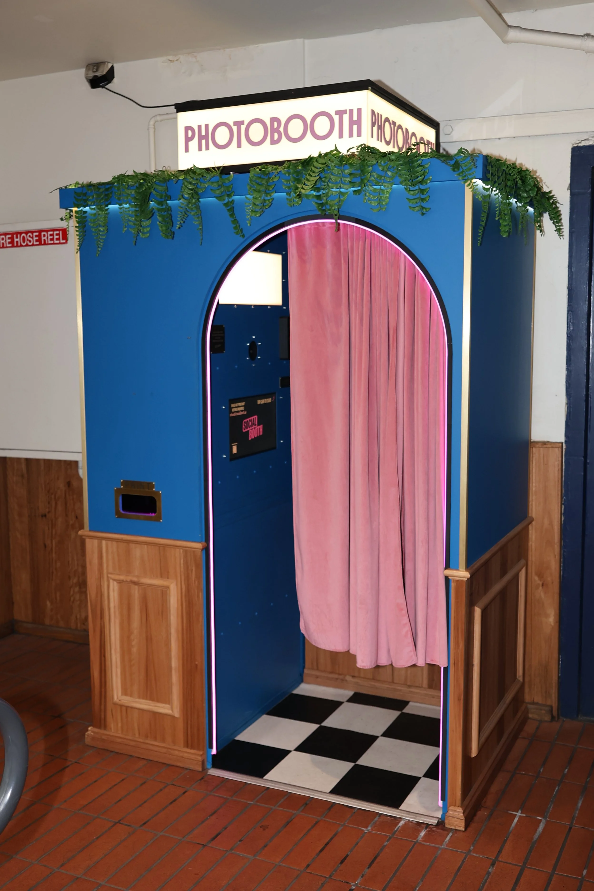 The blue photobooth with a pink curtain on the Good Heavens rooftop