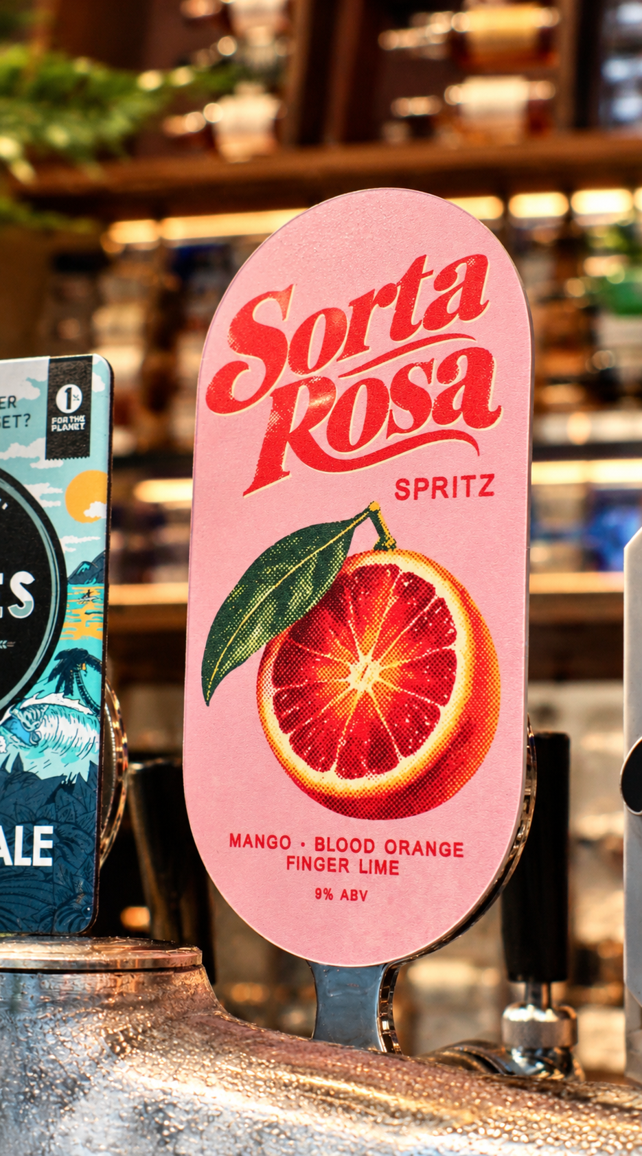The pink Sorta Rosa spritz tap badge on the bar at Good Heavens, showing a blood orange illustration