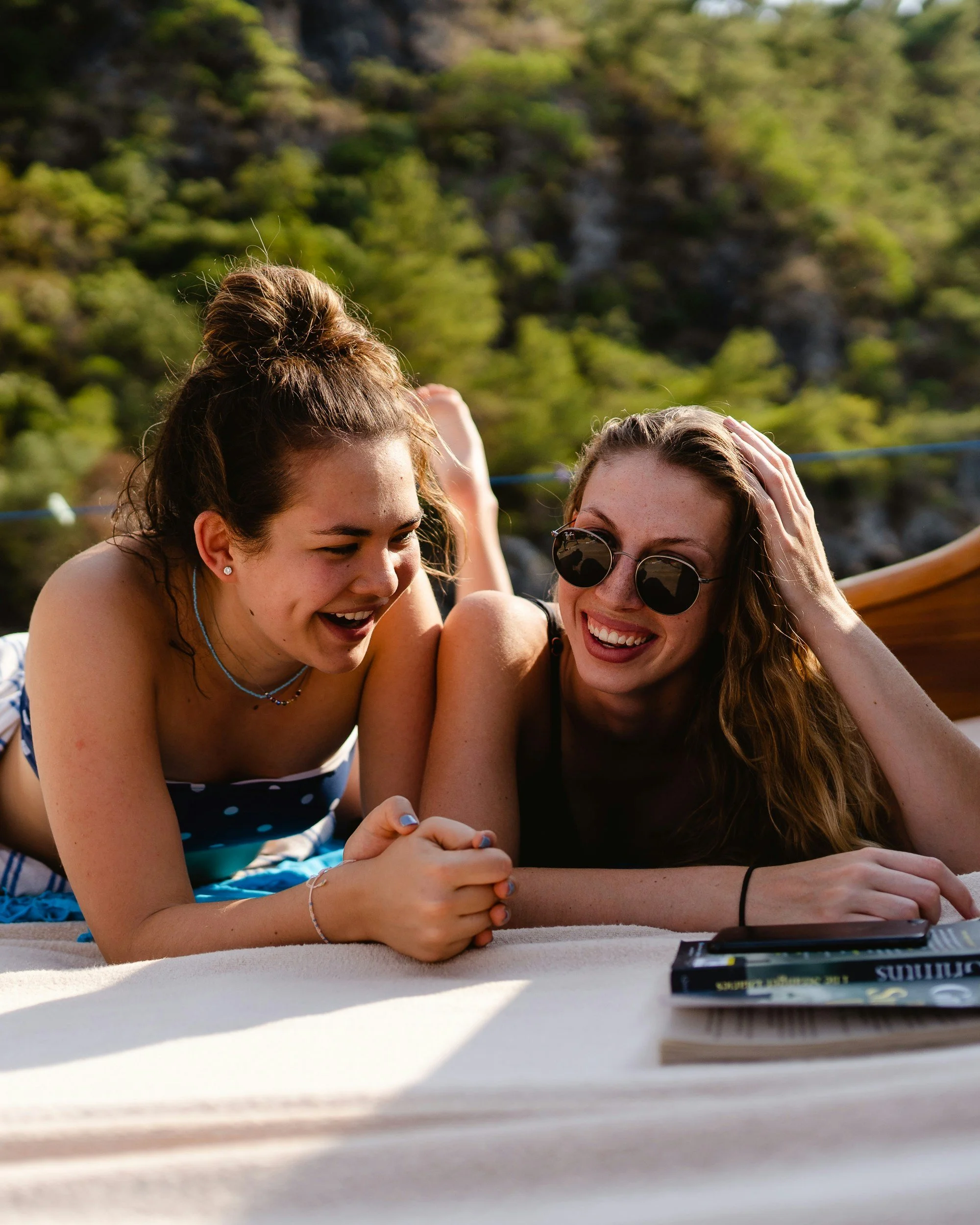 two teenage females laying outside smiling