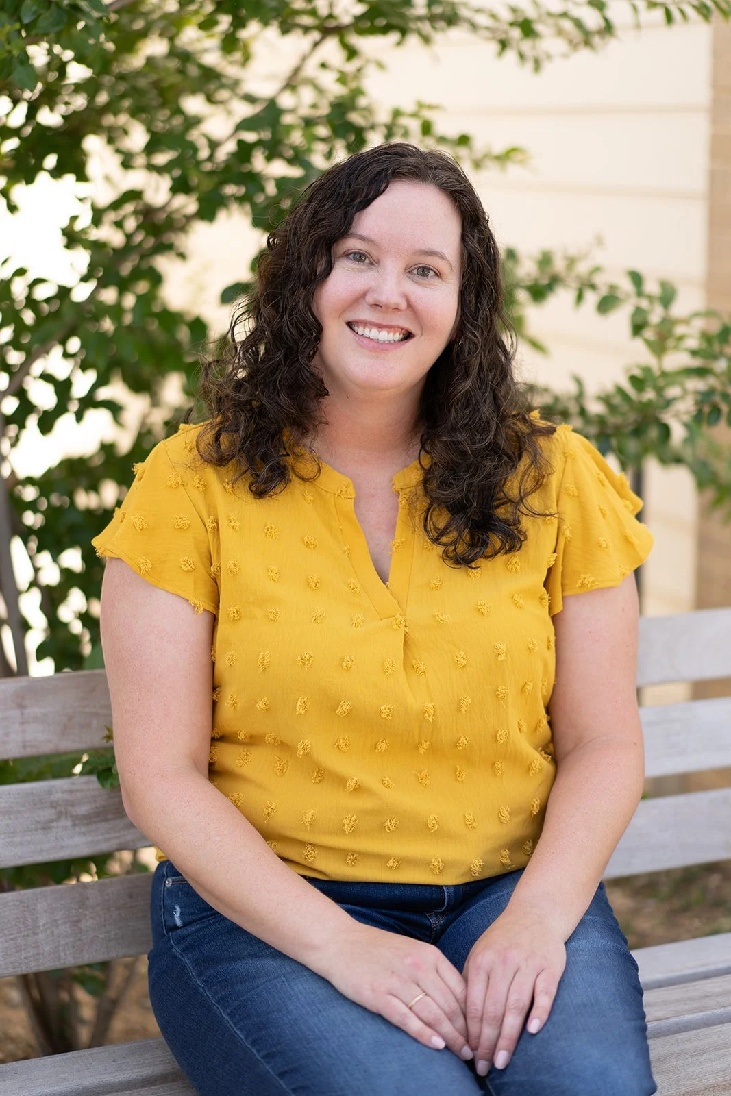 Dallas trauma therapist smiling while sitting on bench