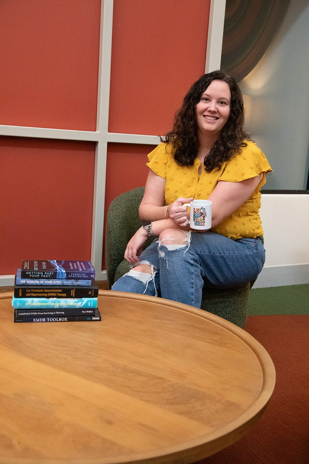 anxiety therapist sitting with coffee mug smiling