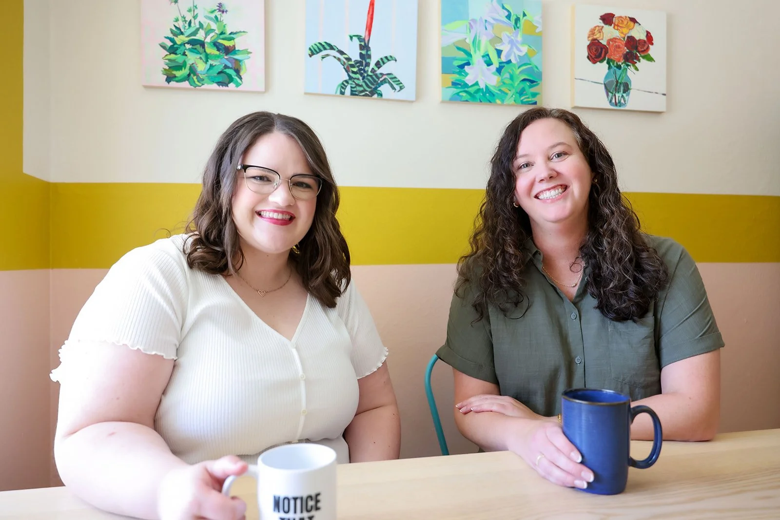Dallas trauma therapists sitting with coffee mugs at table smiling
