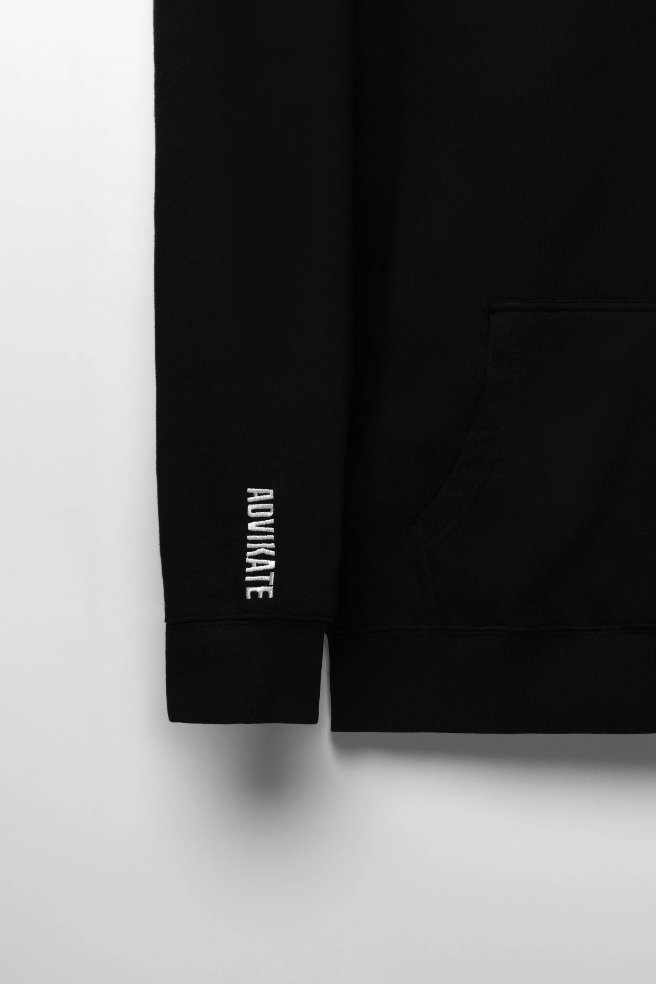 Close-up of ADVIKATE text logo embroidery on the right sleeve of the ADVIKATE Classic Hoodie Series I in Black.