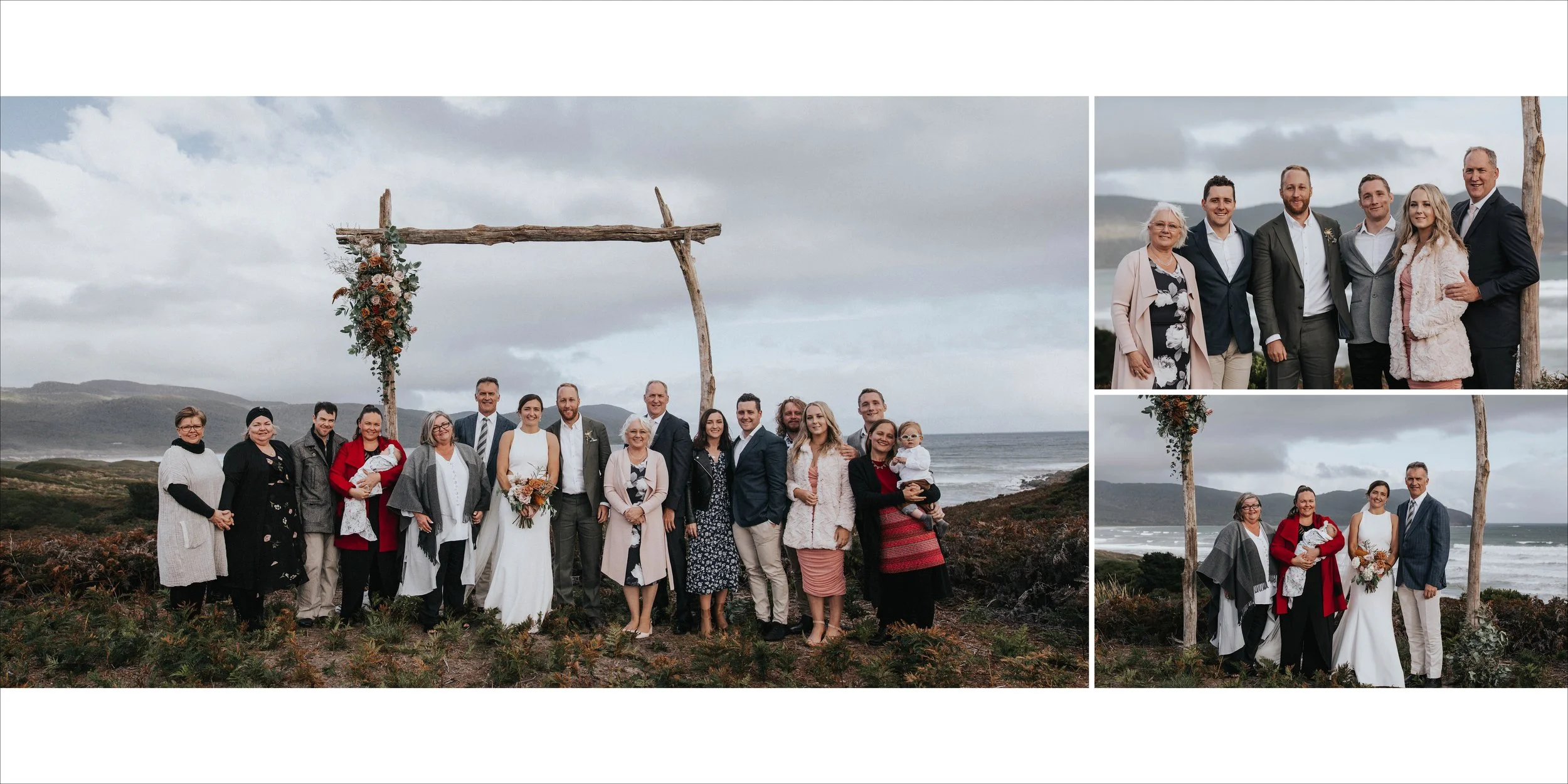 A large group of people, including a bride and groom, posing outdoors at a wedding ceremony site near the coast, with a rustic wooden arch decorated with flowers, under a cloudy sky.