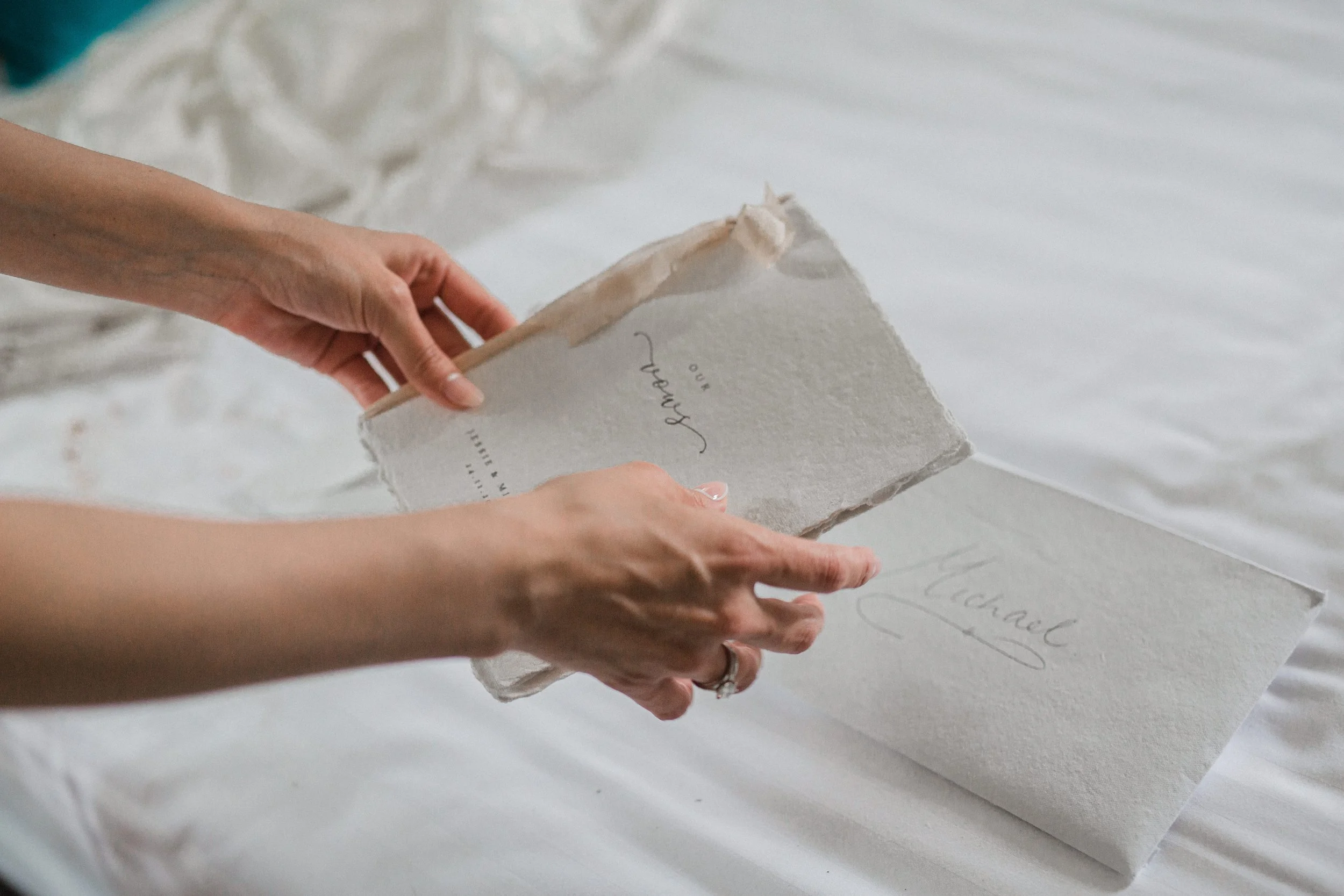 Person flipping through a handmade wedding album with the names 'Chanal' and 'Jerry' on the open pages.
