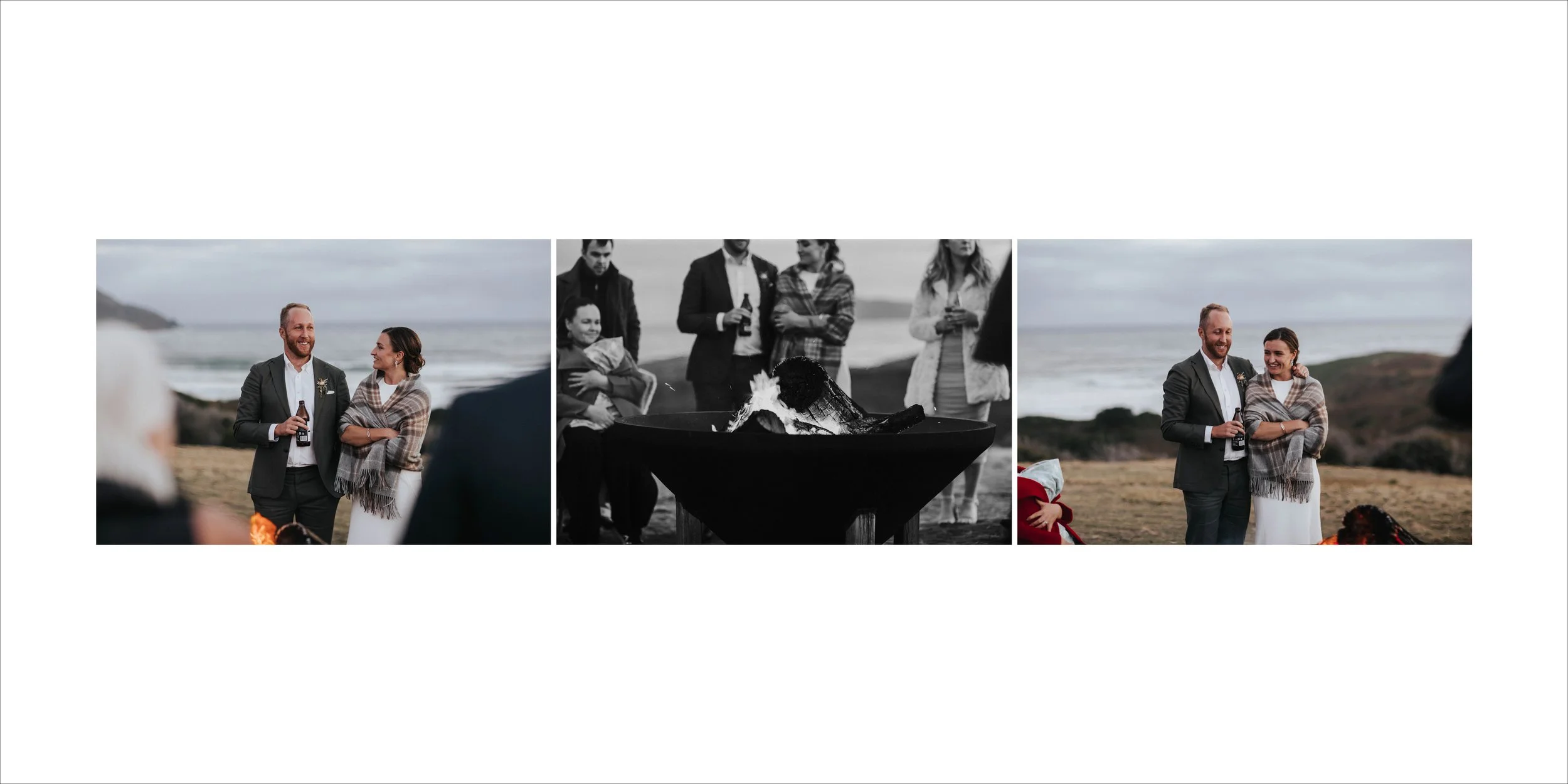 A wedding ceremony taking place outdoors near the beach, with the bride and groom standing together, smiling, as guests watch and a bonfire burns in the background.