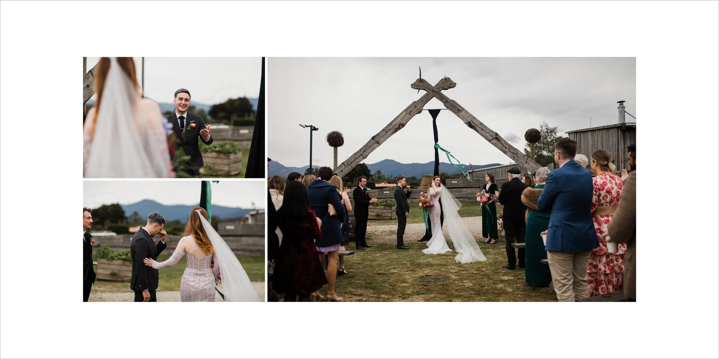 A wedding ceremony taking place outdoors under a rustic wooden arch with mountain views in the background. The bride and groom stand in the center exchanging vows while guests are seated around them. The bride wears a white gown and veil, and the gro