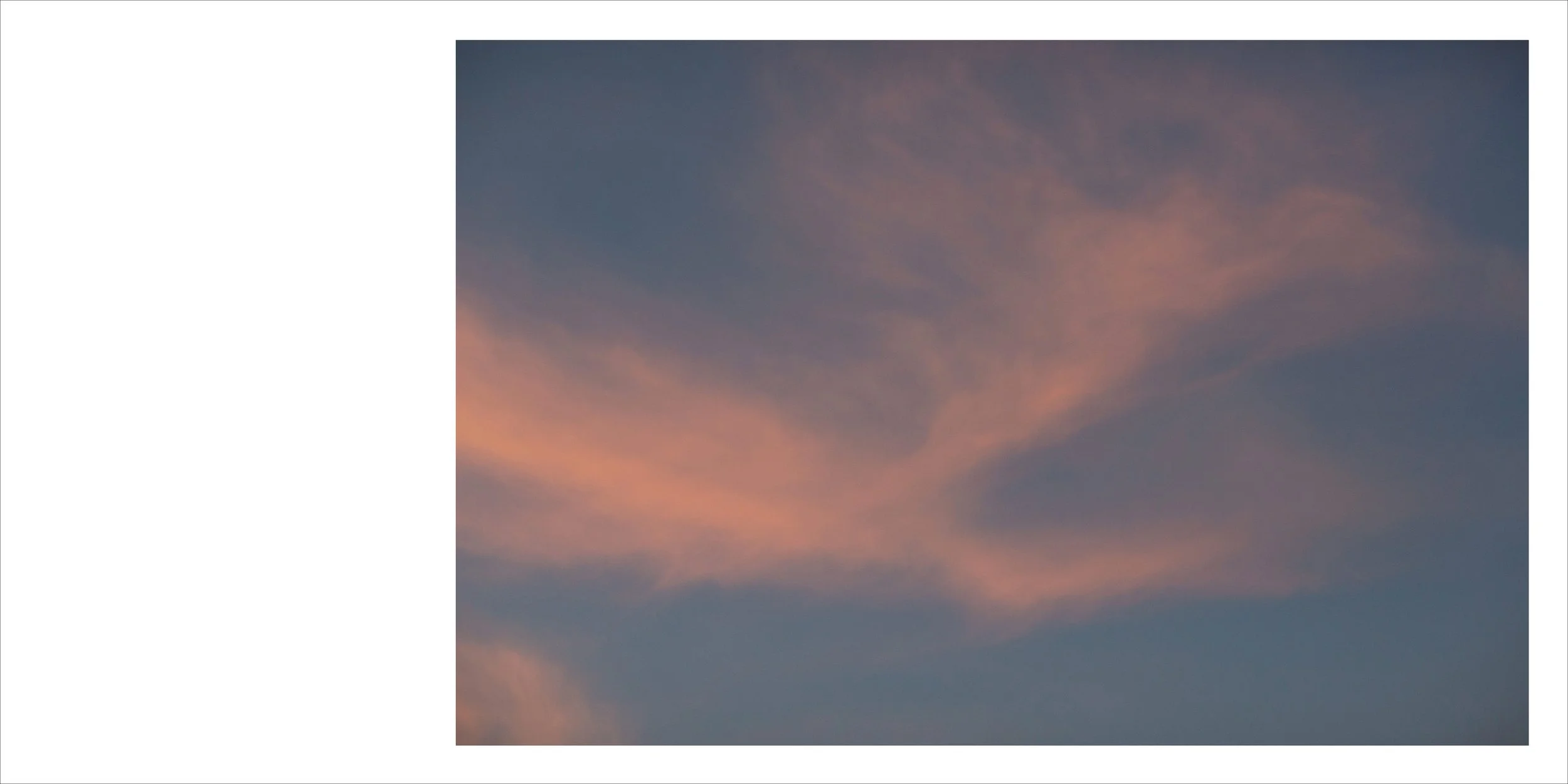 Pink and orange clouds in a blue evening sky.