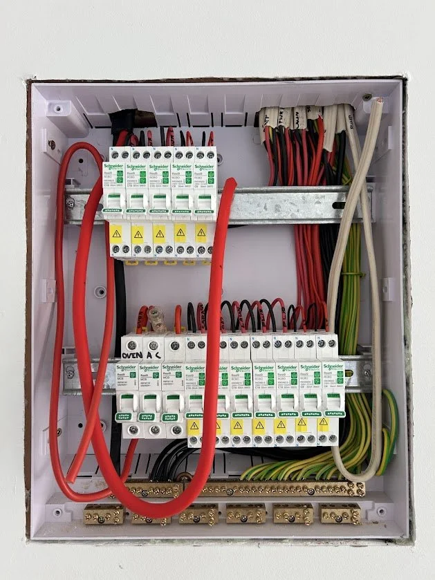 Electrical circuit breaker box with various wires and breakers.