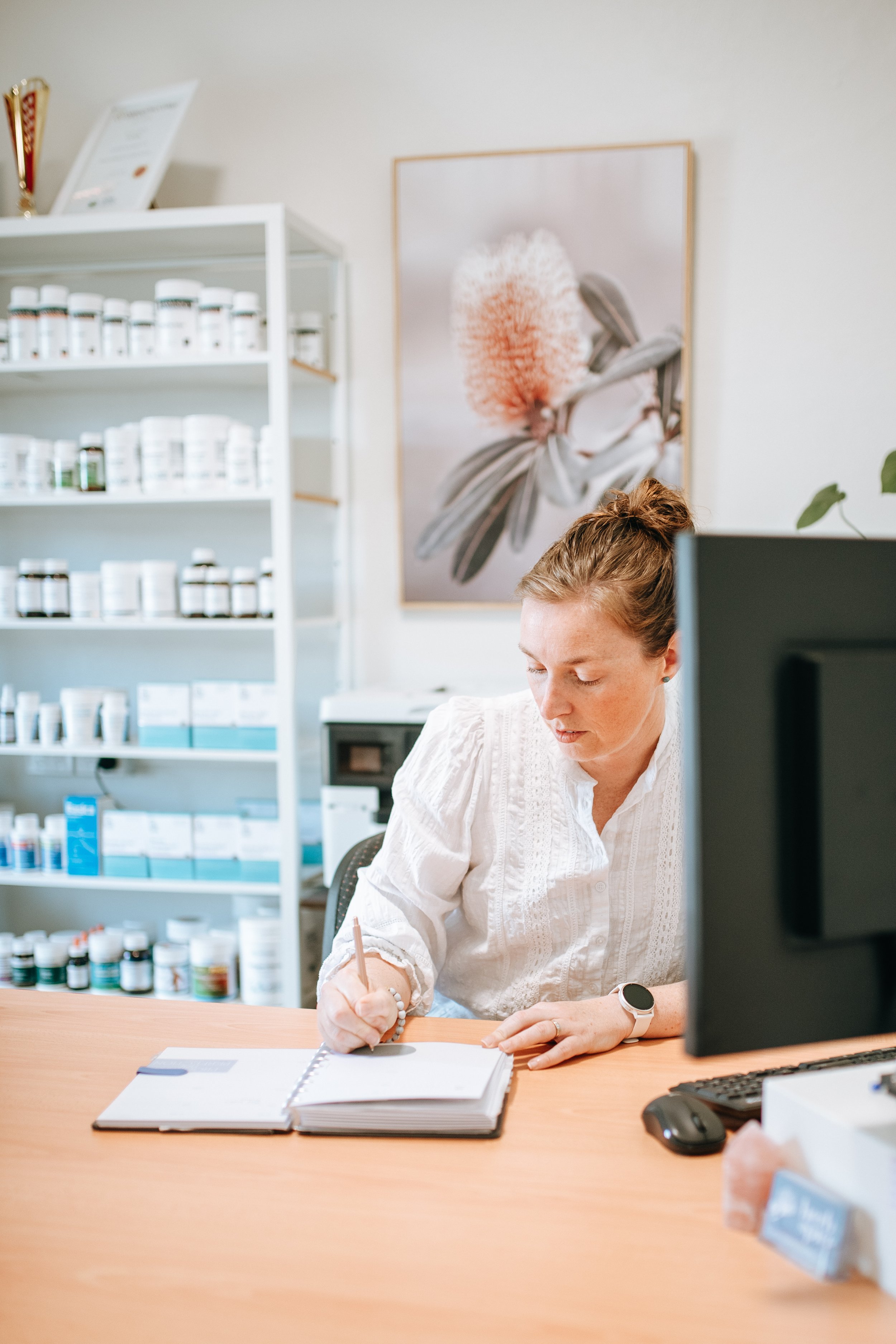 woman sitting at a desk writing in a notebook