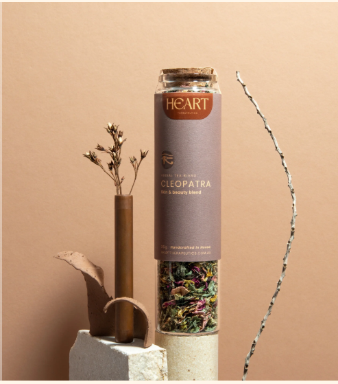 Tall glass jar with a cork stopper and a purple label filled with Cleopatra skin and beauty tea 35g