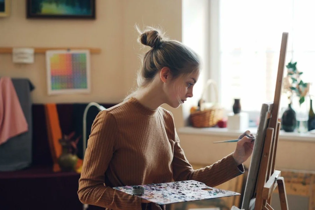 young-woman-painting-in-sunlit-art-studio
