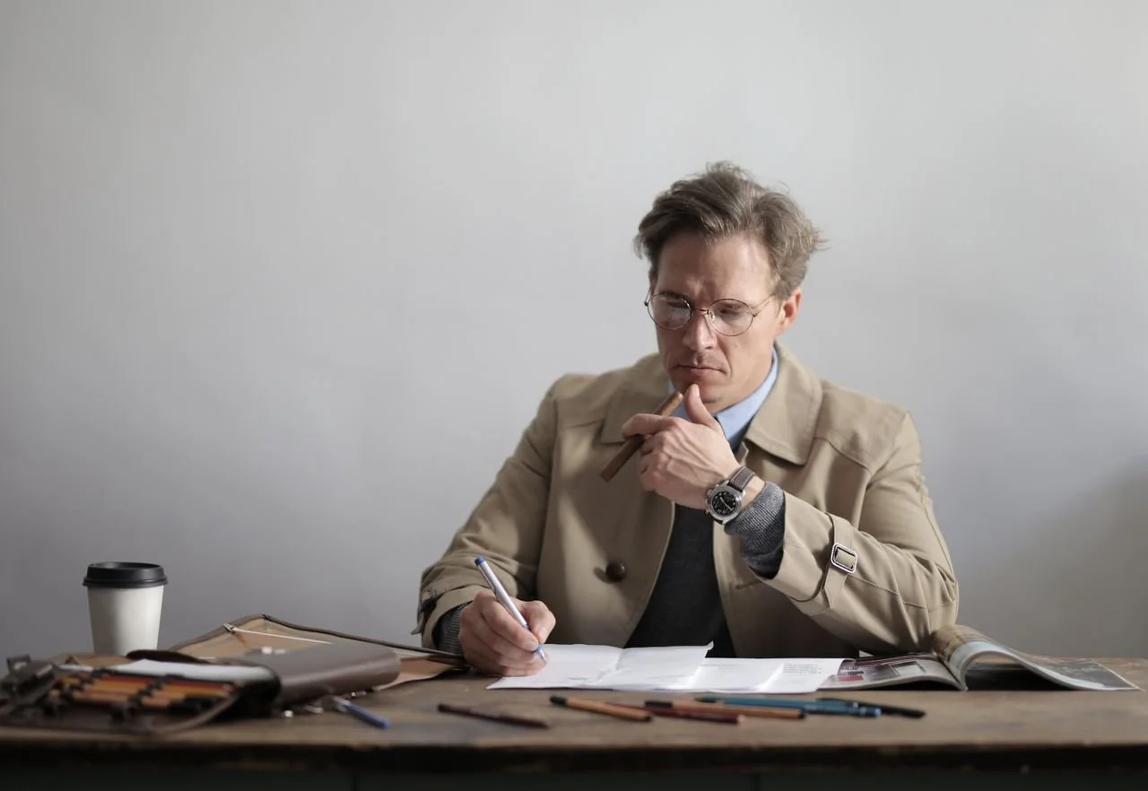 serious-businessman-taking-notes-in-documents-during-coffee-break-in-office