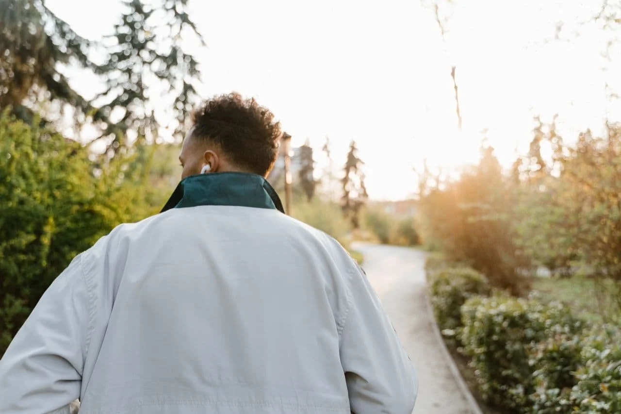 a-back-view-of-a-man-in-a-jacket-walking-at-a-park