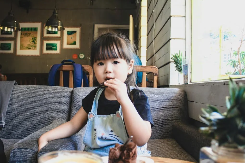 girl-in-blue-and-white-stripe-shirt-sitting-on-gray-couch