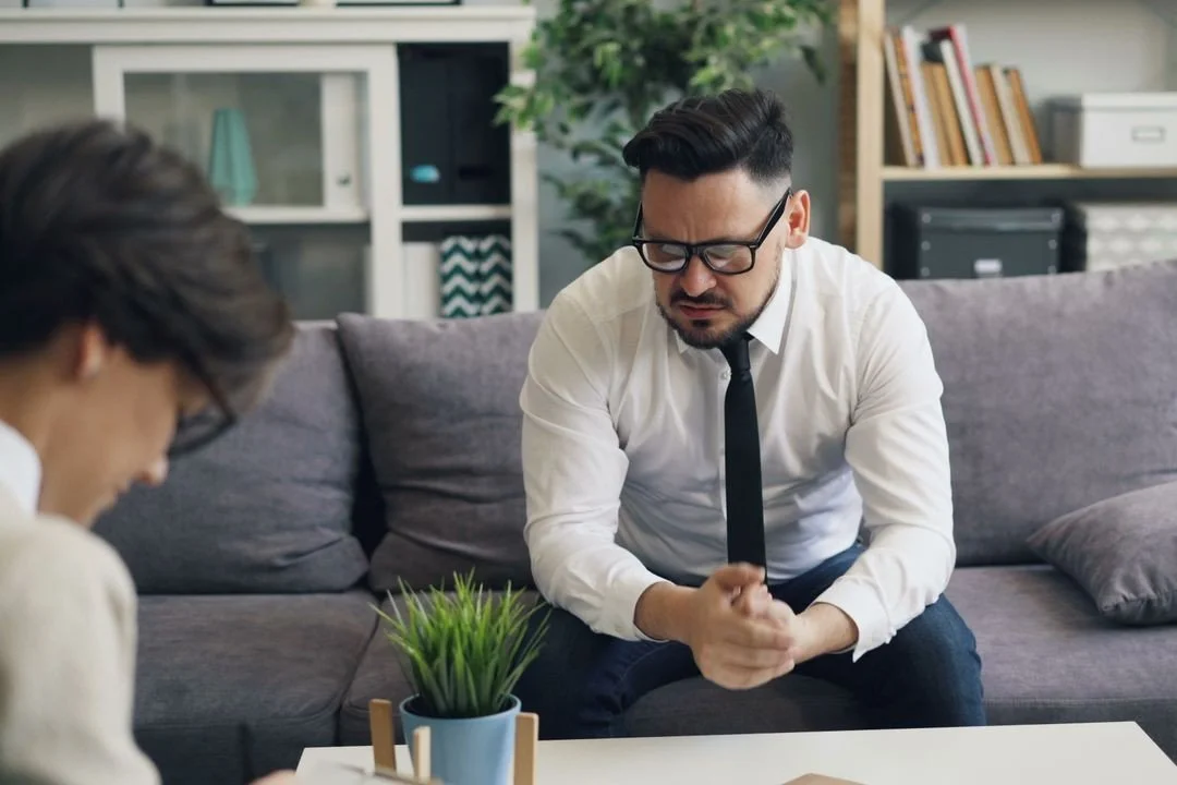 two-people-sitting-on-a-couch-talking-to-each-other