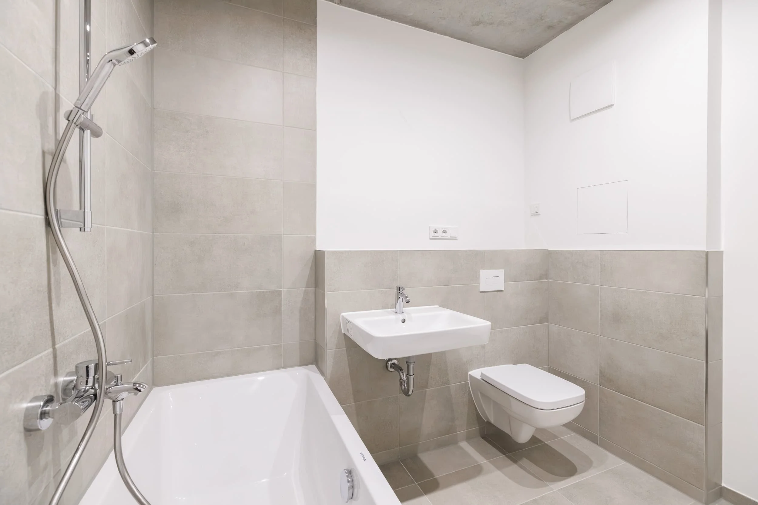 Modernes Badezimmer mit Dusche, Waschbecken, WC, beige Fliesen und weißen Wänden.