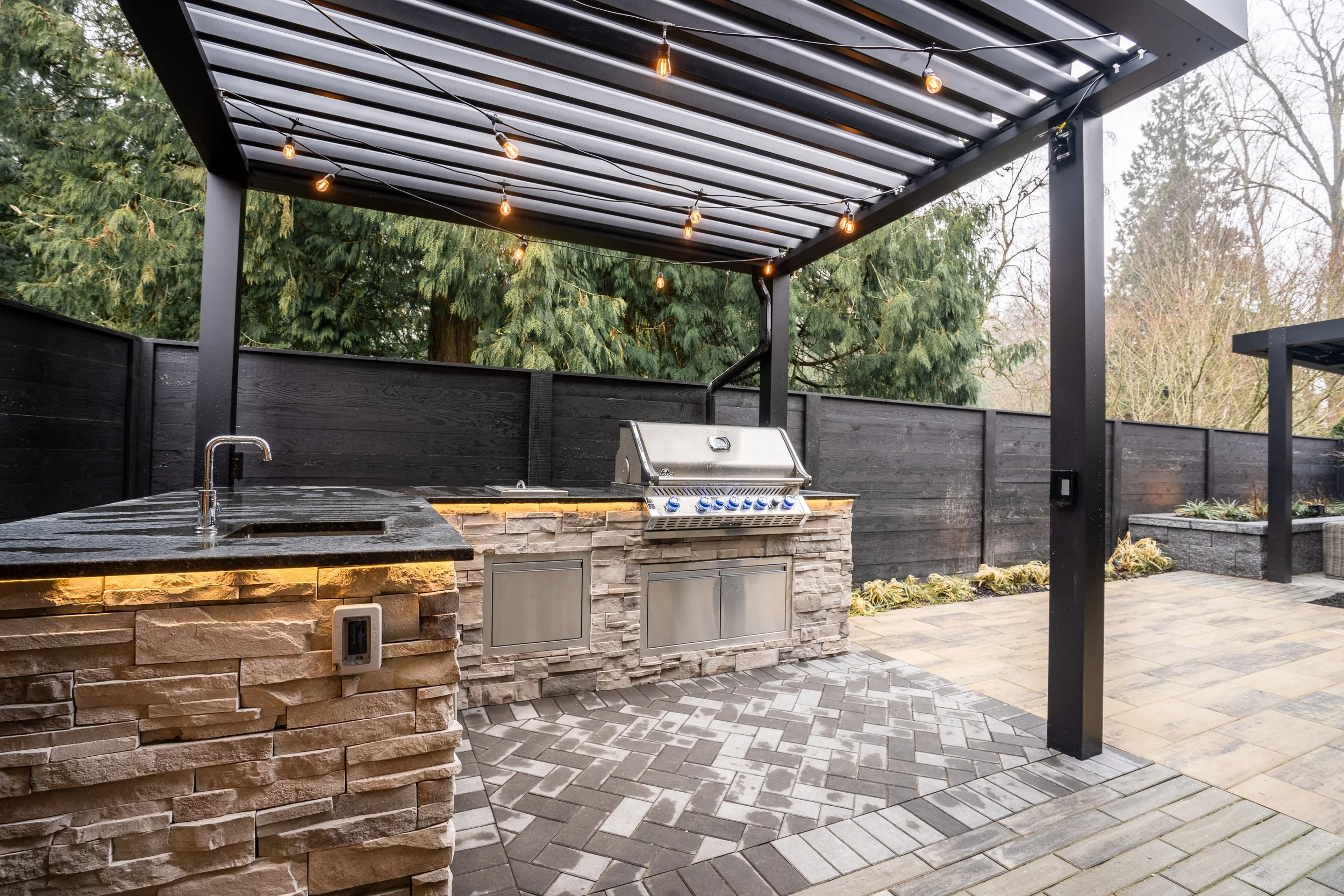 Louvered roof covering outdoor kitchen with Napoleon grill.