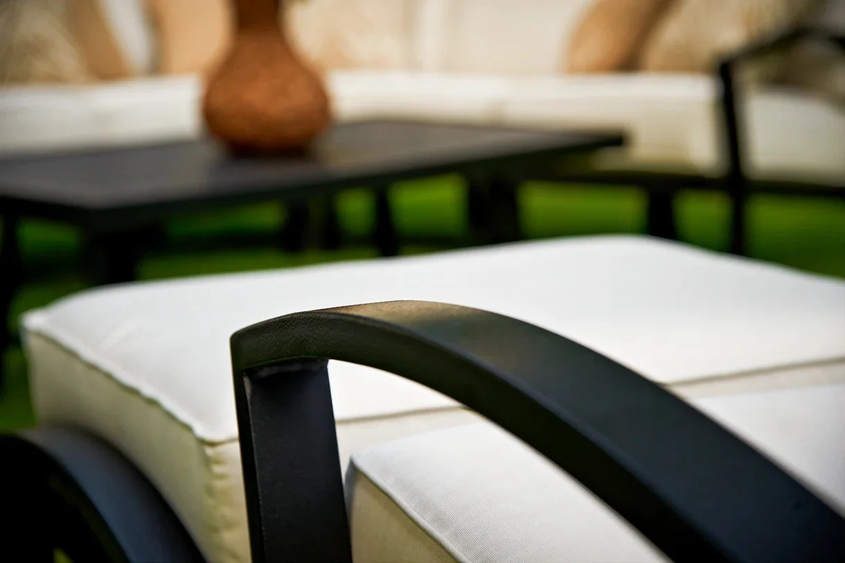 close up of wrought iron arm chair with white cushions