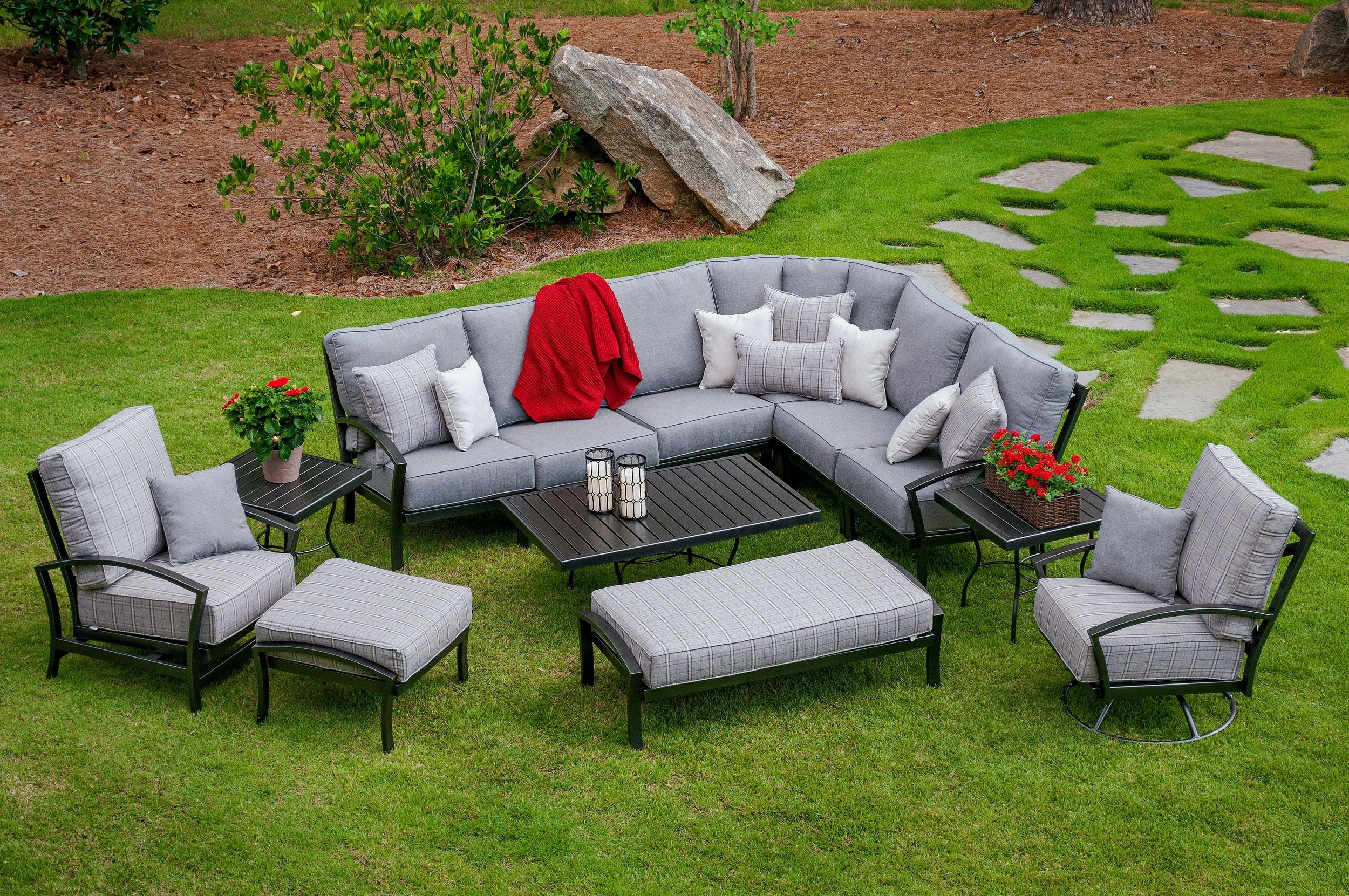 l shaped wrought iron sectional with lounge chairs, ottomans, coffee and end tables on grass