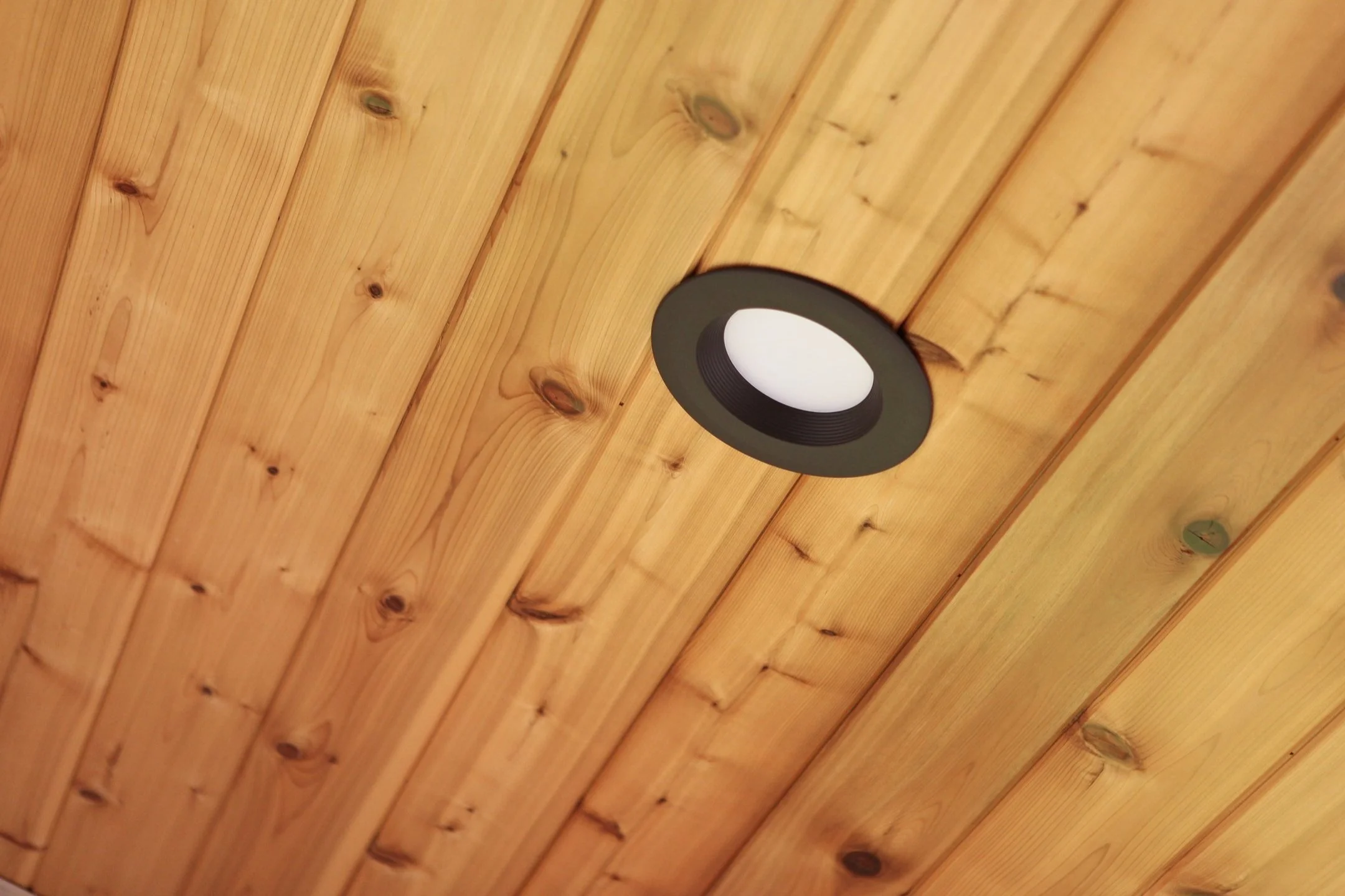 Ceiling with wooden planks and a recessed ceiling light