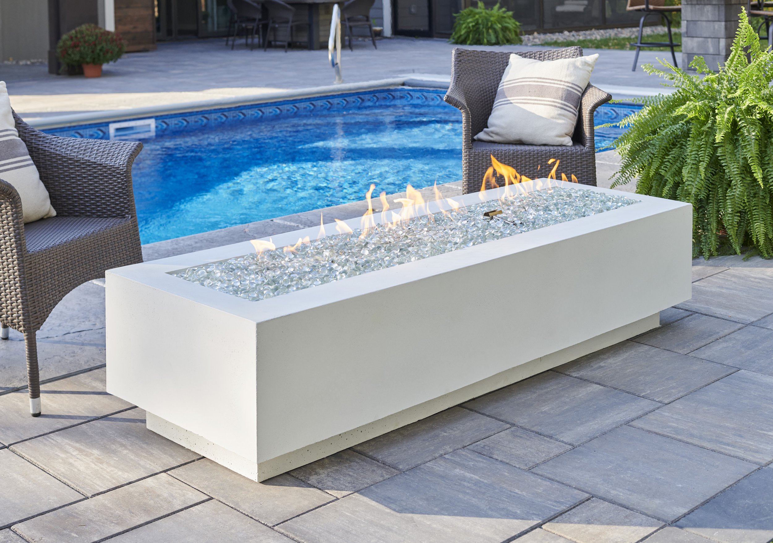 white cove fire table next to pool