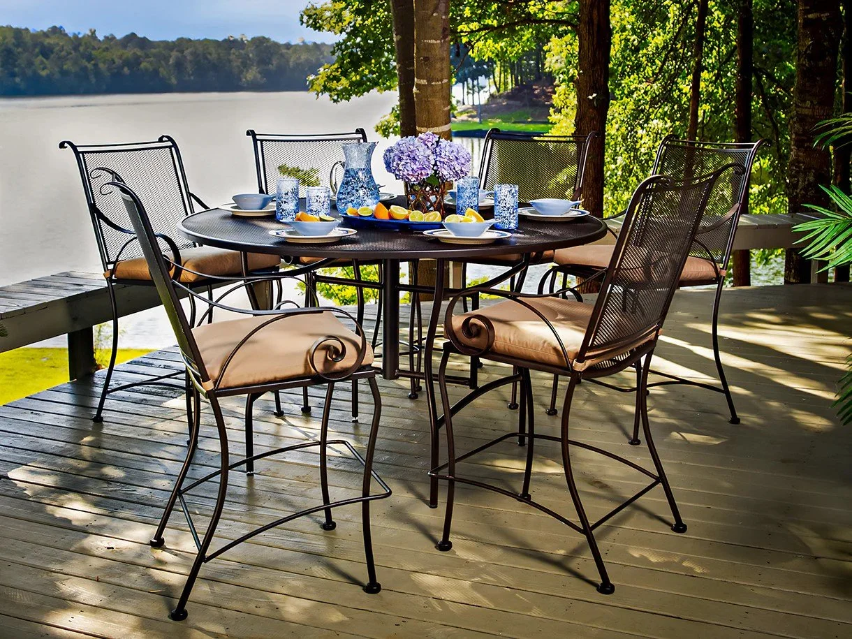 7 piece hight top dining set with brown cushions on deck next to lake
