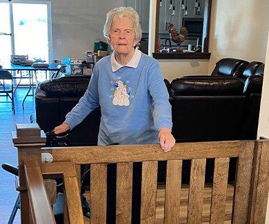 Aging adult standing by Gatekeepers custom wood safety gate