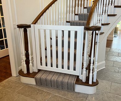 Custom white wooden gate at bottom of staircase