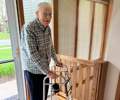 Elderly man with walker by custom wood safety gate