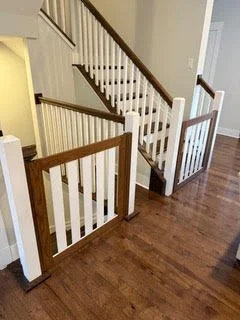 White and dark wood safety gates installed both going upstairs and downstairs