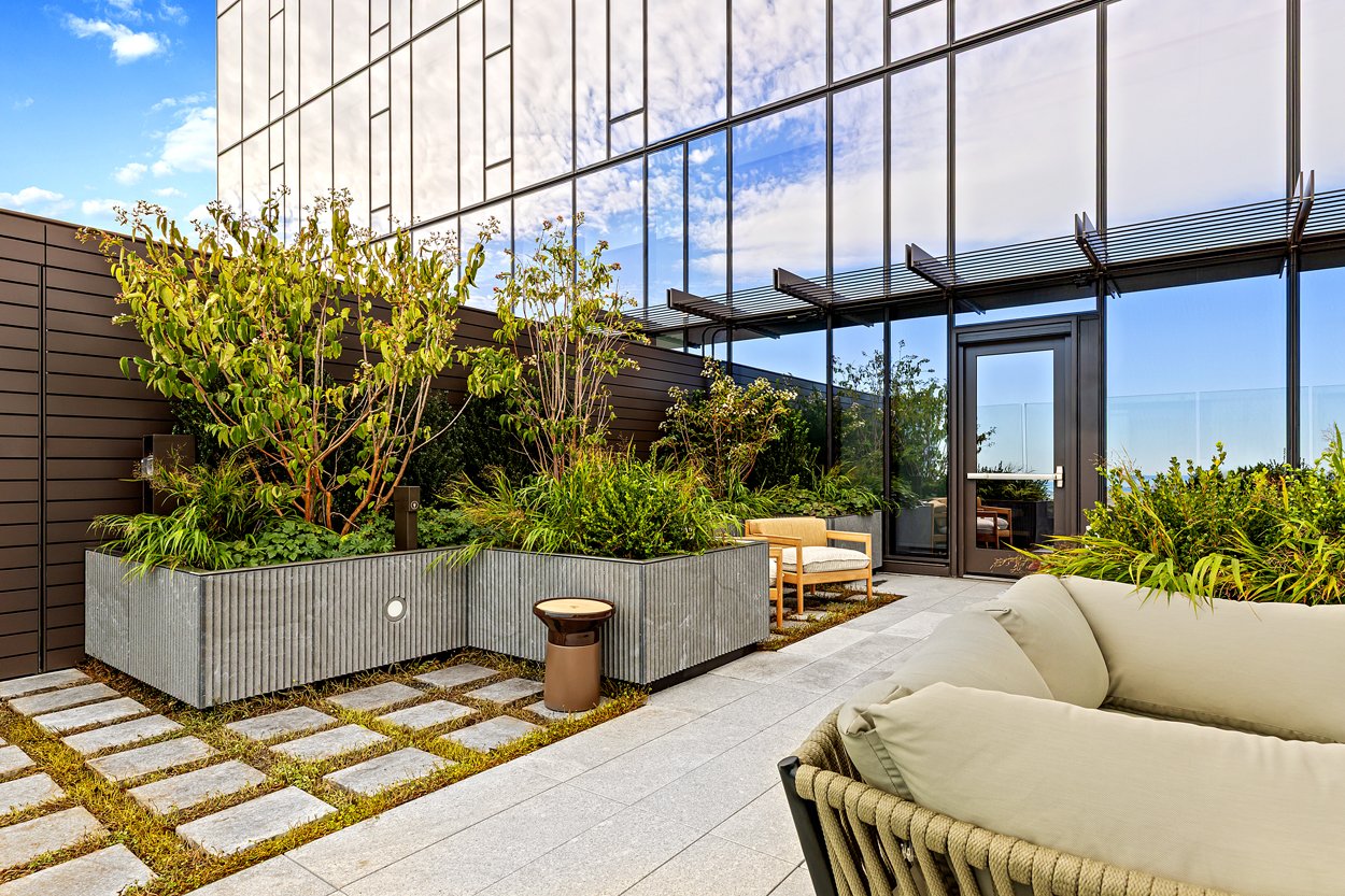 Upper floor balcony at the new South Station Tower in Boston. With unique planters, greenery, and granite paving installed by Xquisite Landscaping shown. 