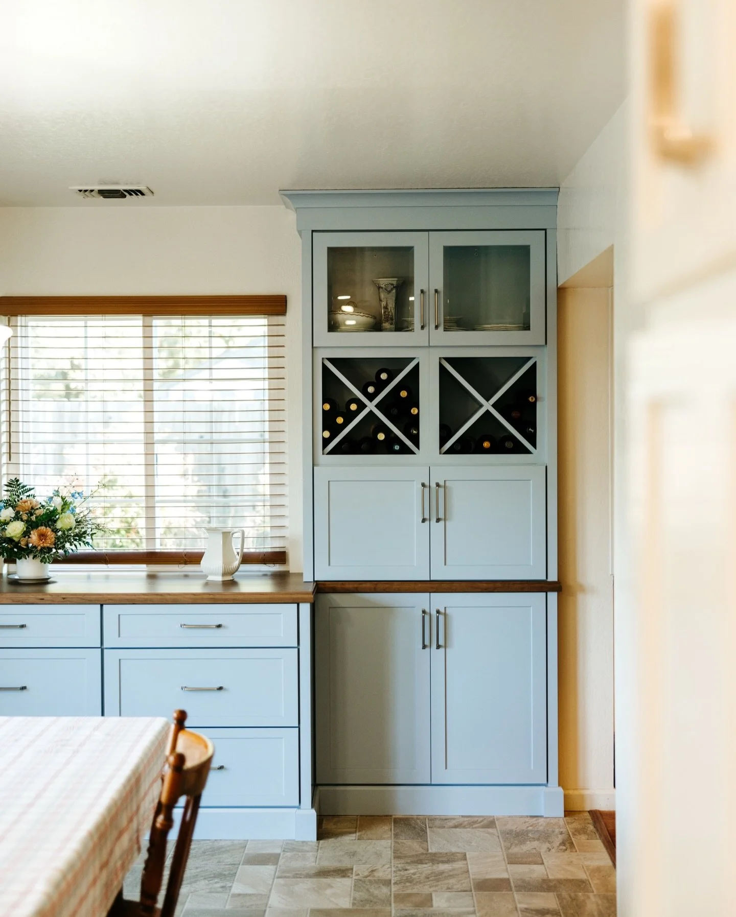 What better way to fill up empty wall space than adding more storage and a designated place for your wine 🍷 

With a soft blue cabinet finish, silver handles, and a wood top, we think this addition finished off this kitchen perfectly in yet another 