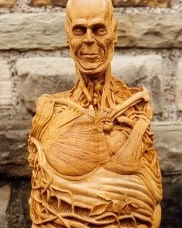 Hand carved repurposed gelatong wood sculpture of a spurious medical anatomy figure with vine growing through abdomen by Jason Thomson UK sculptor