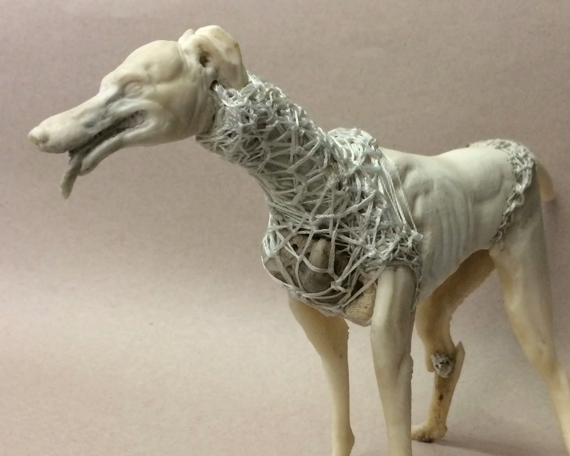 Stitched Hound bone and antler carving of a sighthound with tongue hanging out by Jason Thomson