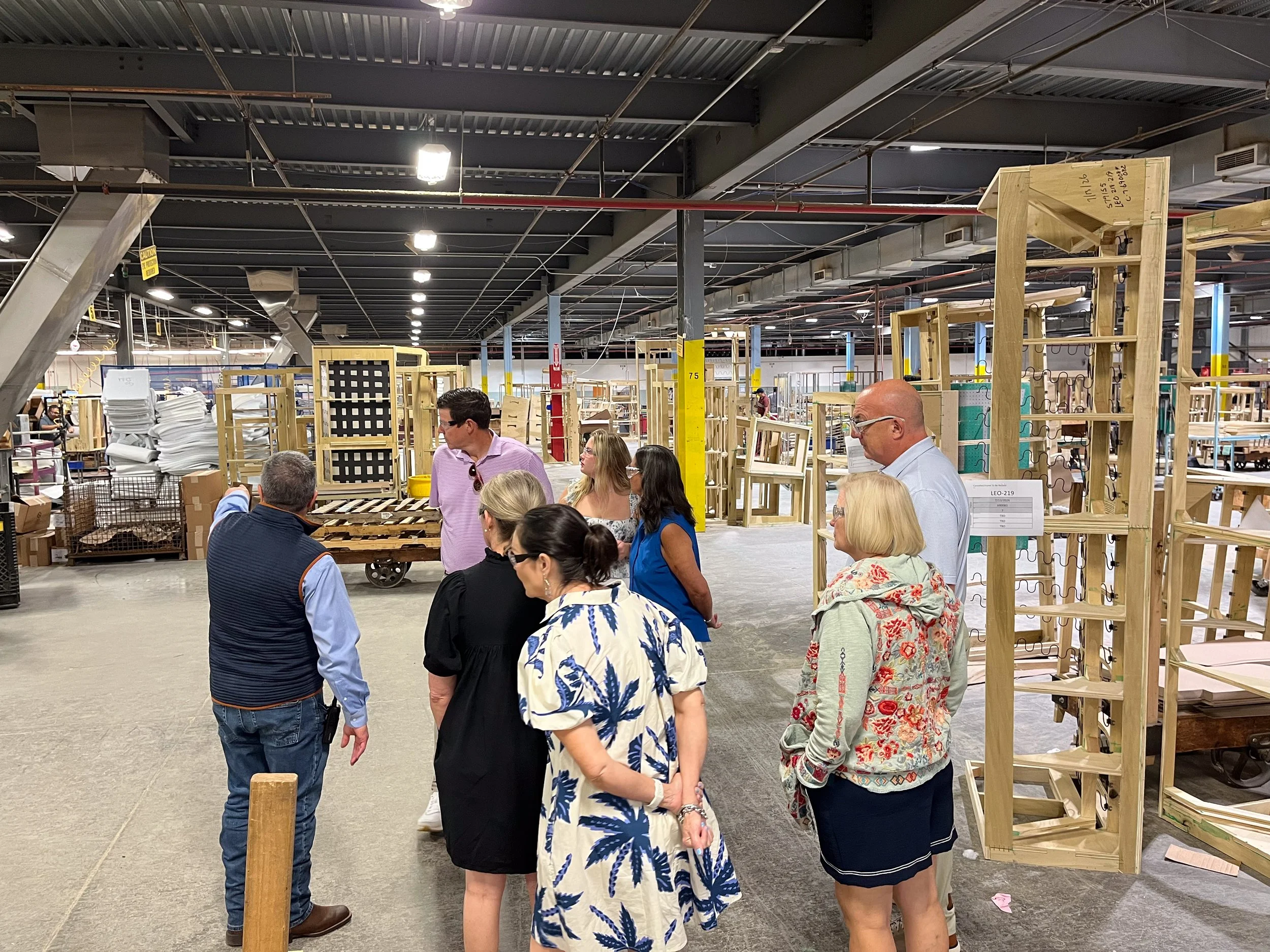Curated team members speaking with a Rowe furniture factory working during a tour of the Salem, Virginia manufacturing facility.
