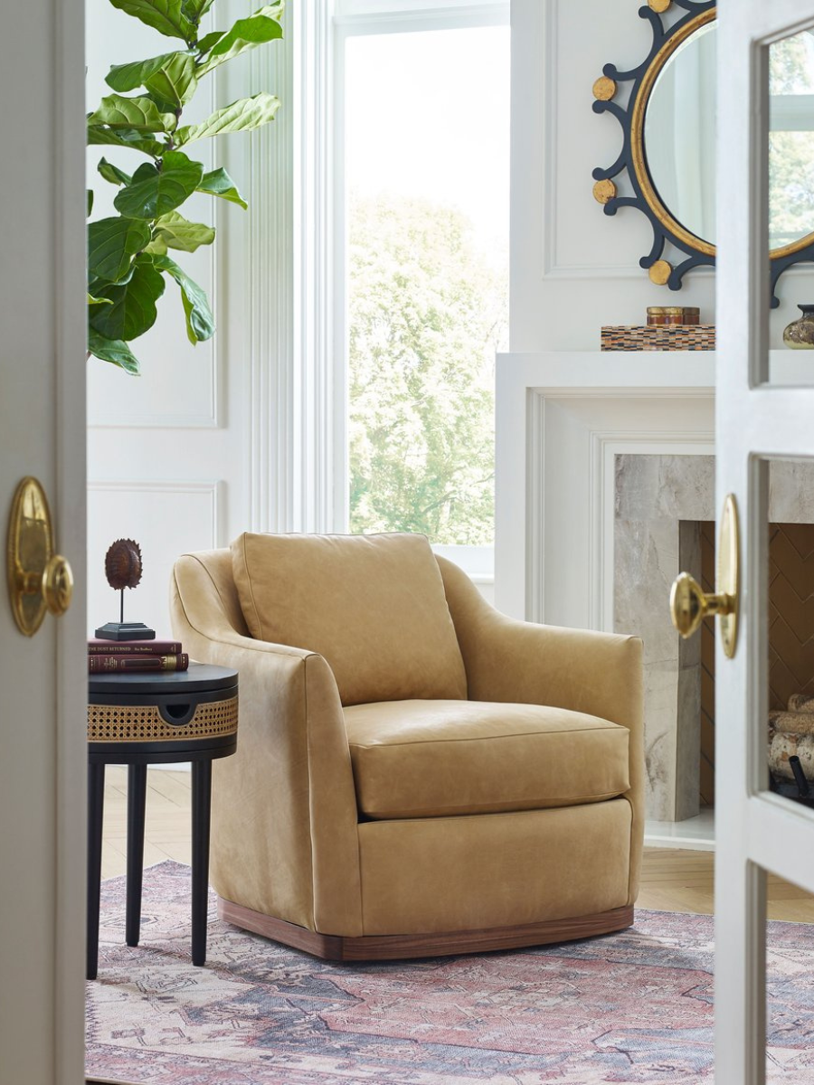 The Remy Swivel Chair is shown in a styled living room setting, complete with a rug and accent table.