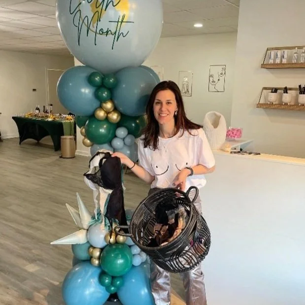 Libby Basile, Owner of Filly Rose Bra Fitting Studio, holding donated bras