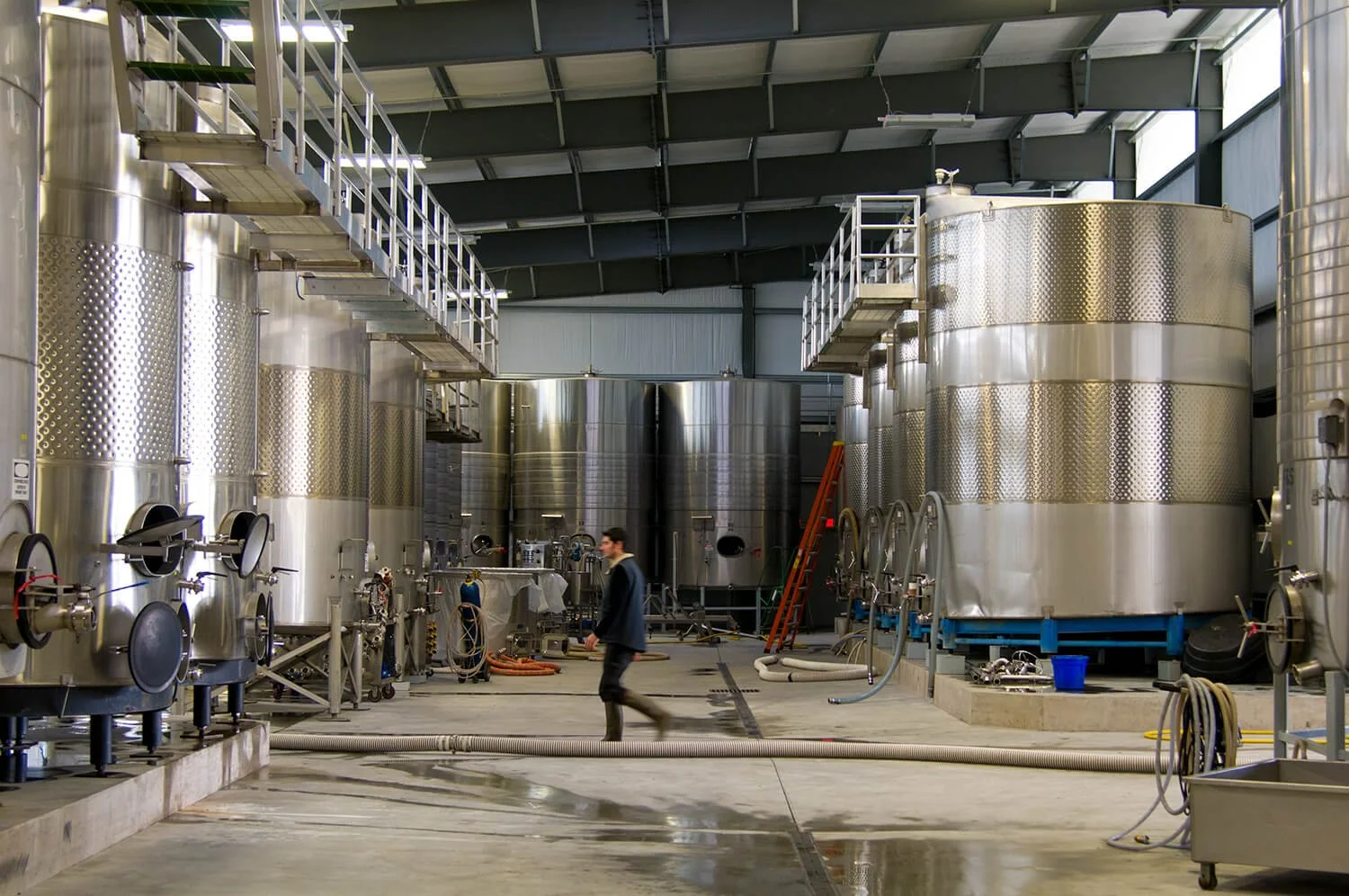 Large vats arranged in a U shape inside the production facility at NW Wine Company.