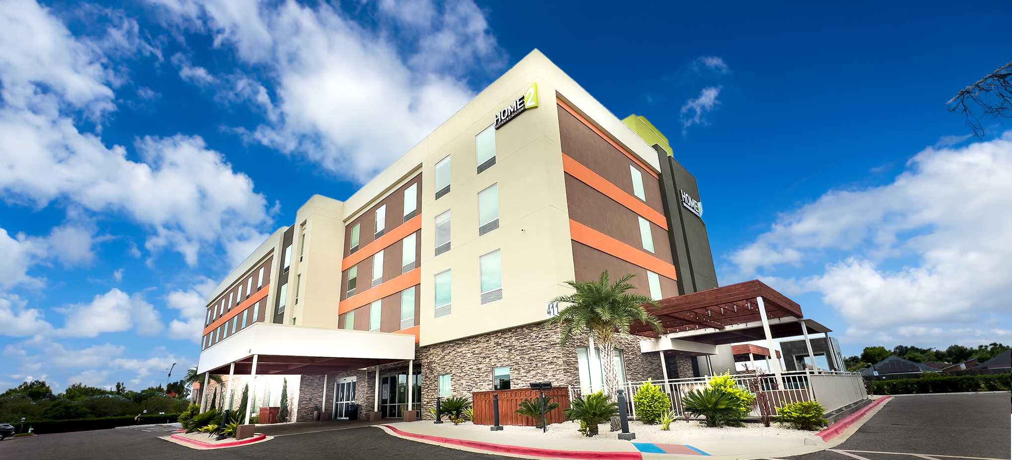 home 2-Suites angle view with clouds.png