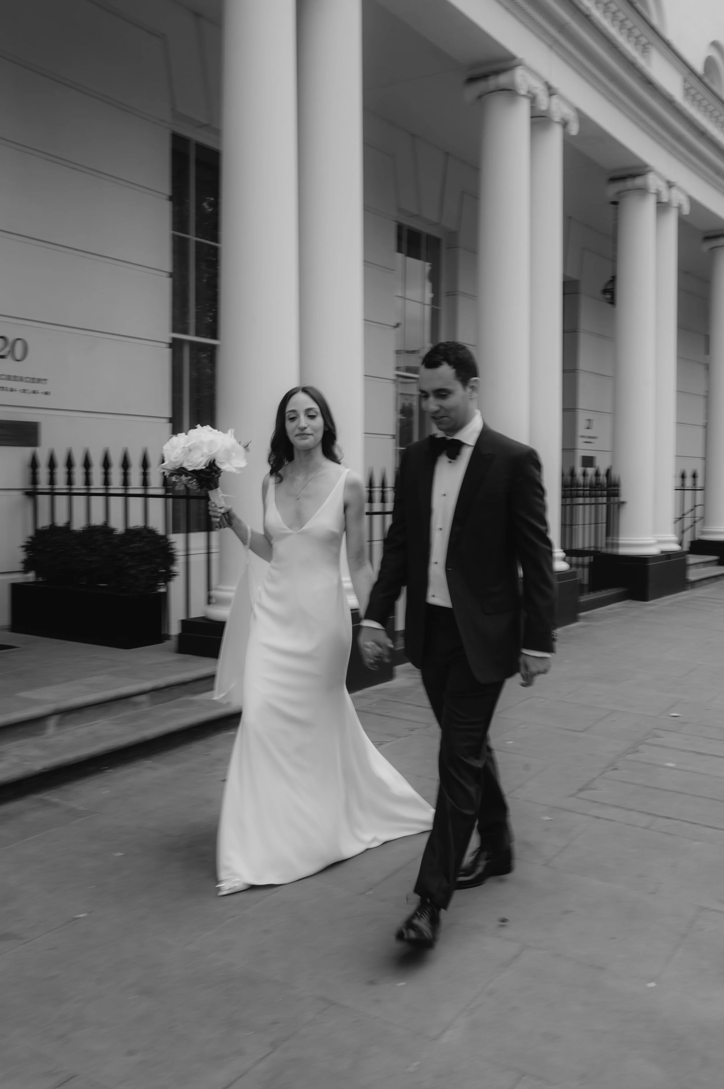 London wedding photography at Marylebone Town Hall bride and groom walking holdings hands