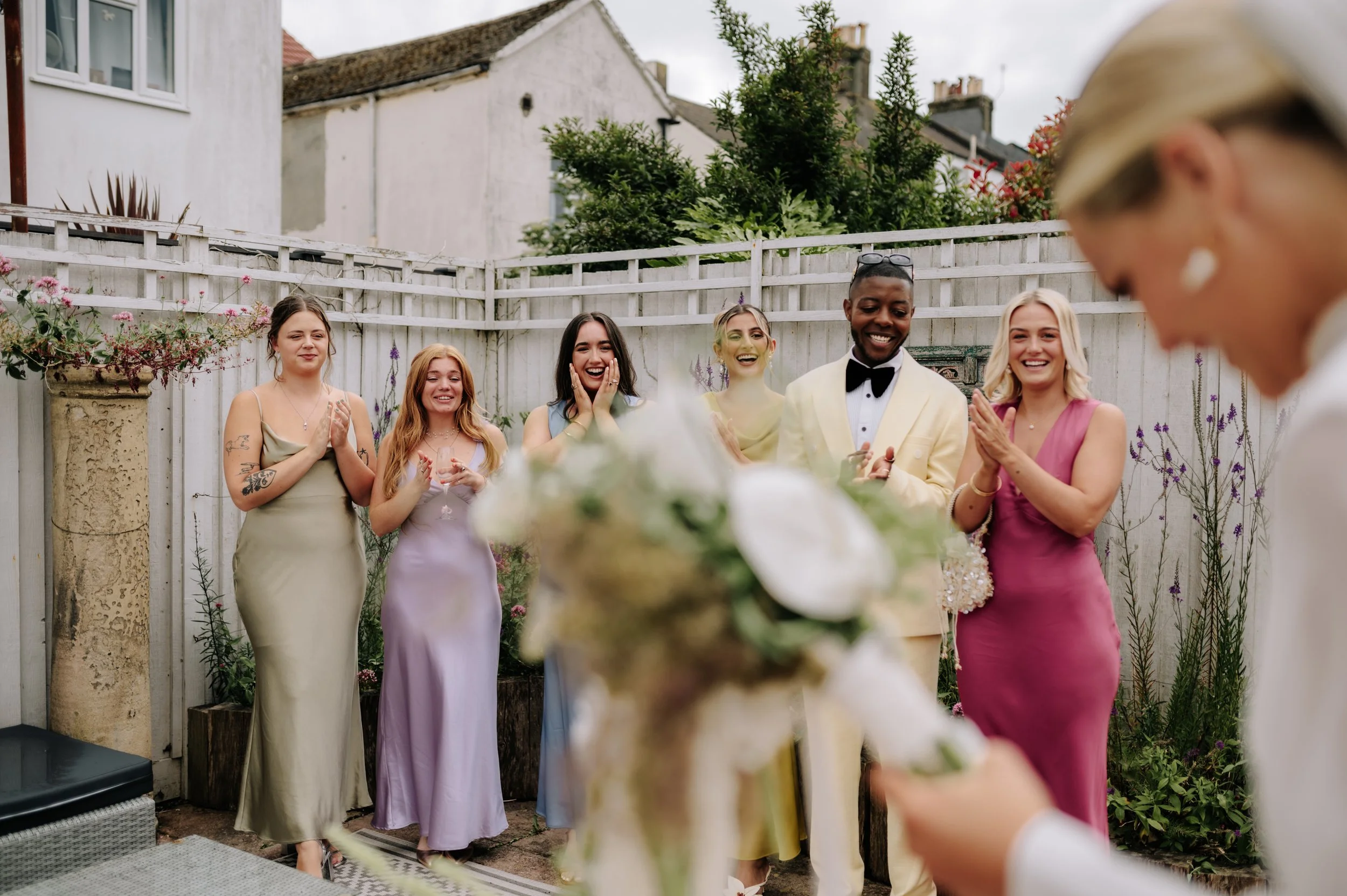 Wedding party reacting to seeing bride in wedding dress at Brighton wedding. Fine art documentary wedding photography. 