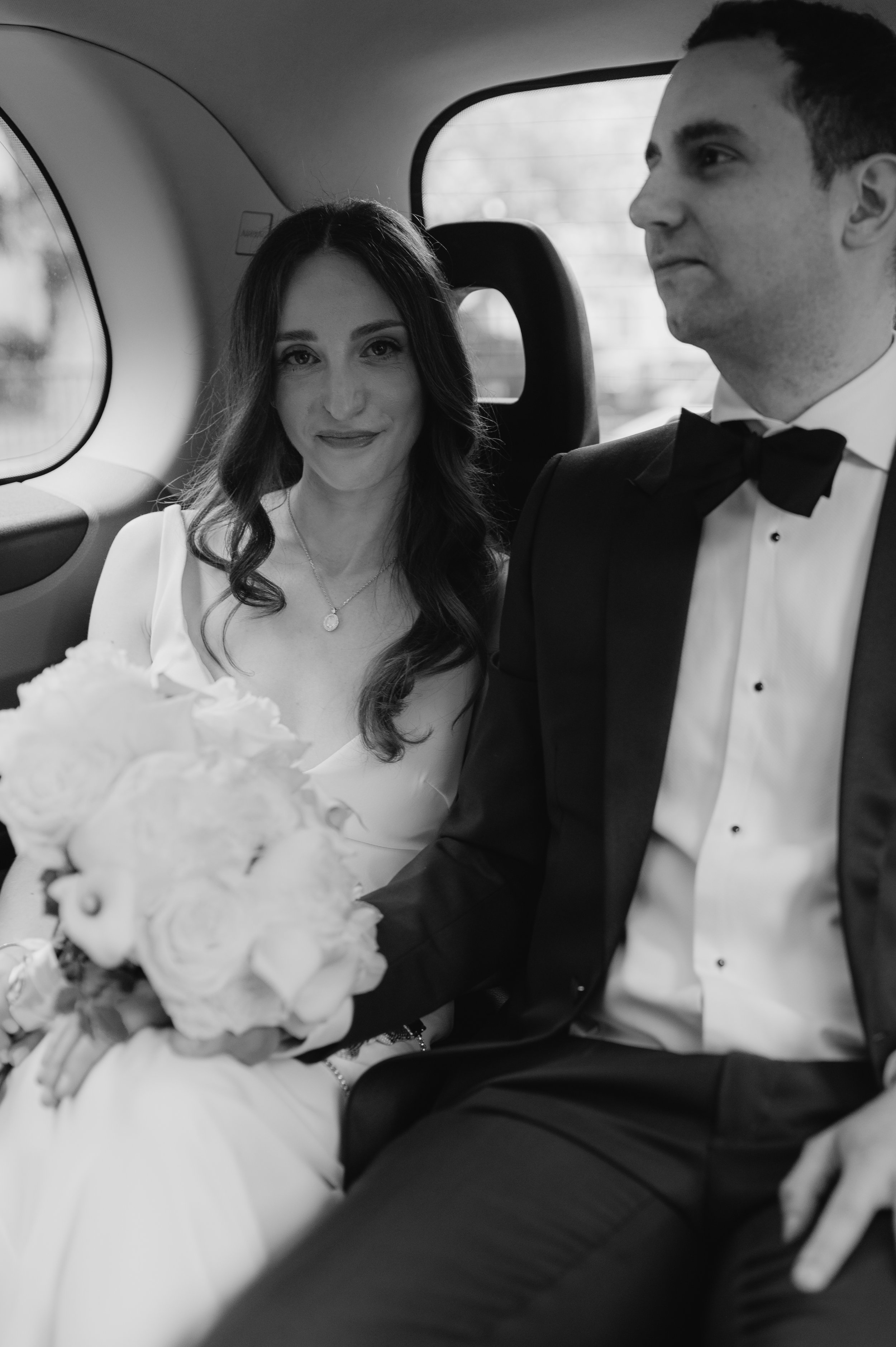 London wedding photography at Marylebone Town Hall bride smiling at camera in taxi