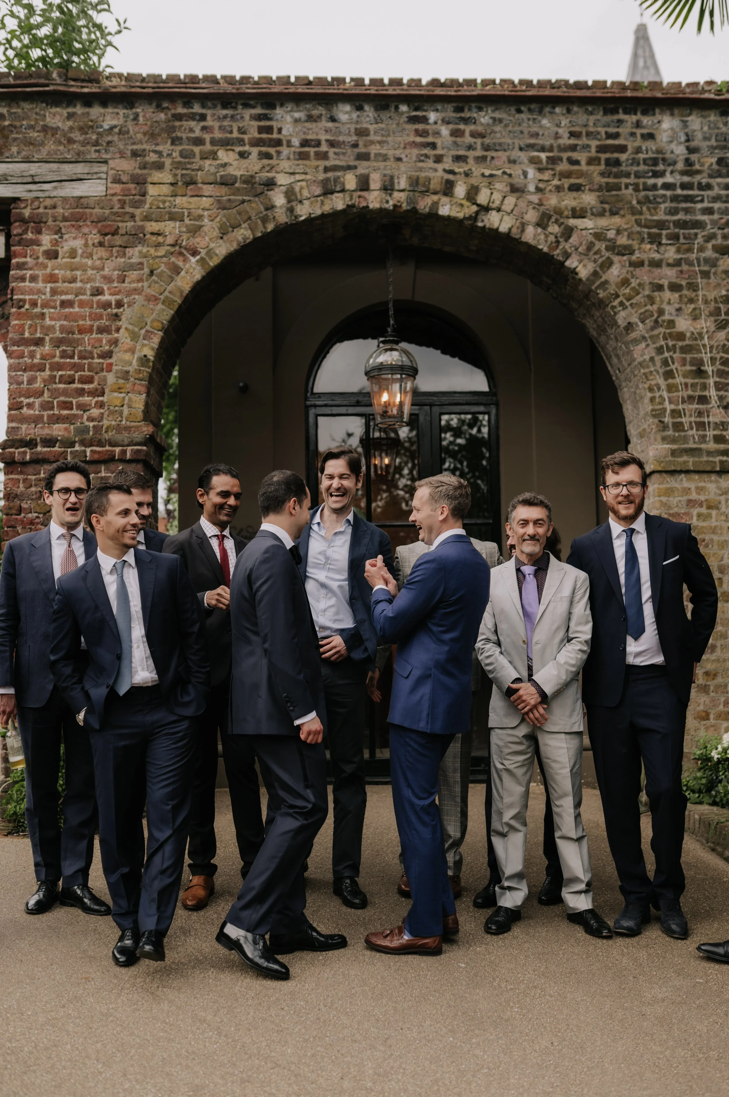 London wedding photography at Belvedere in Holland Park groom laughing with friends 