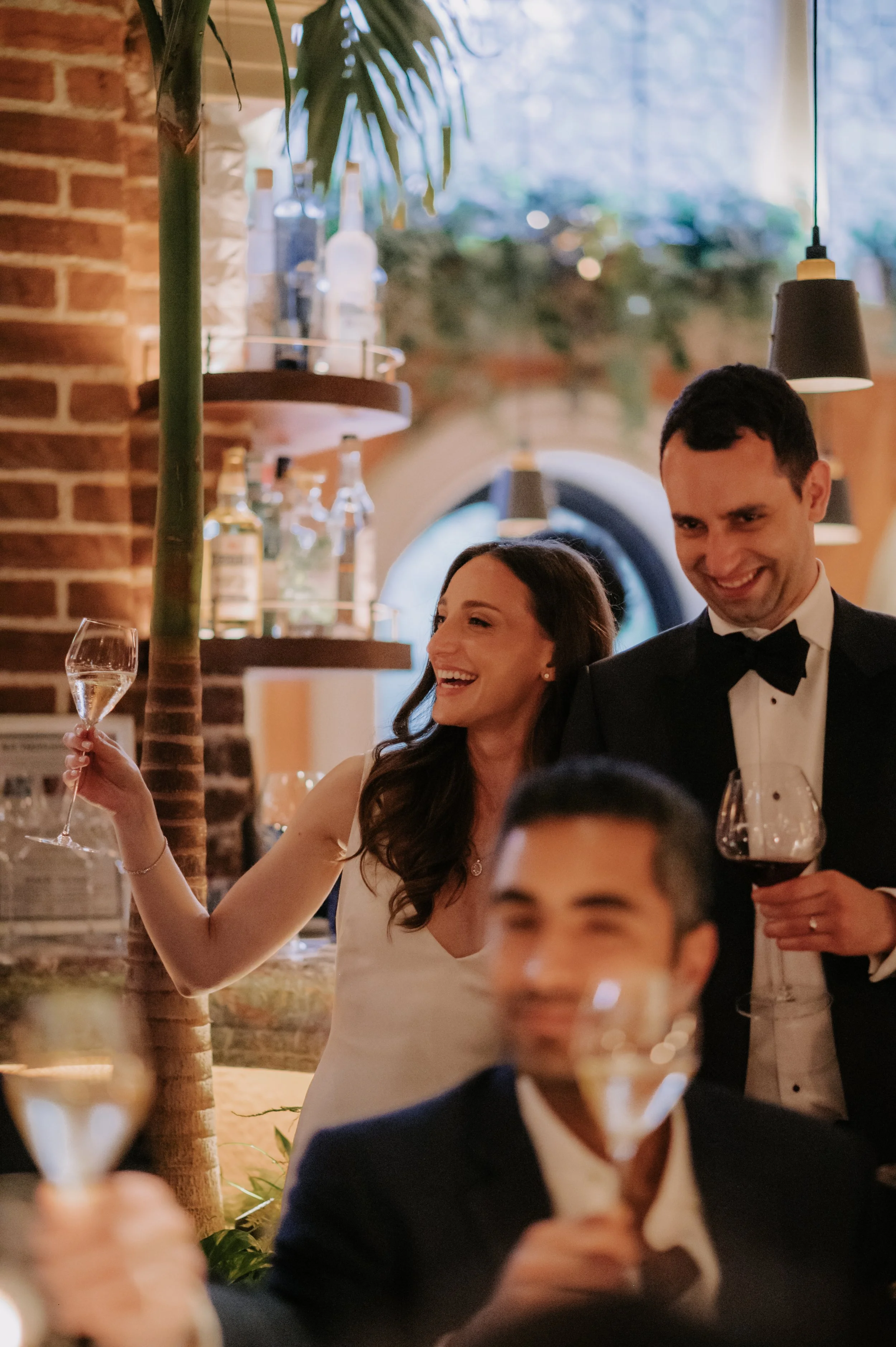 candlelit dinner London wedding photography at Belvedere in Holland Park bride and groom cheering during speech 