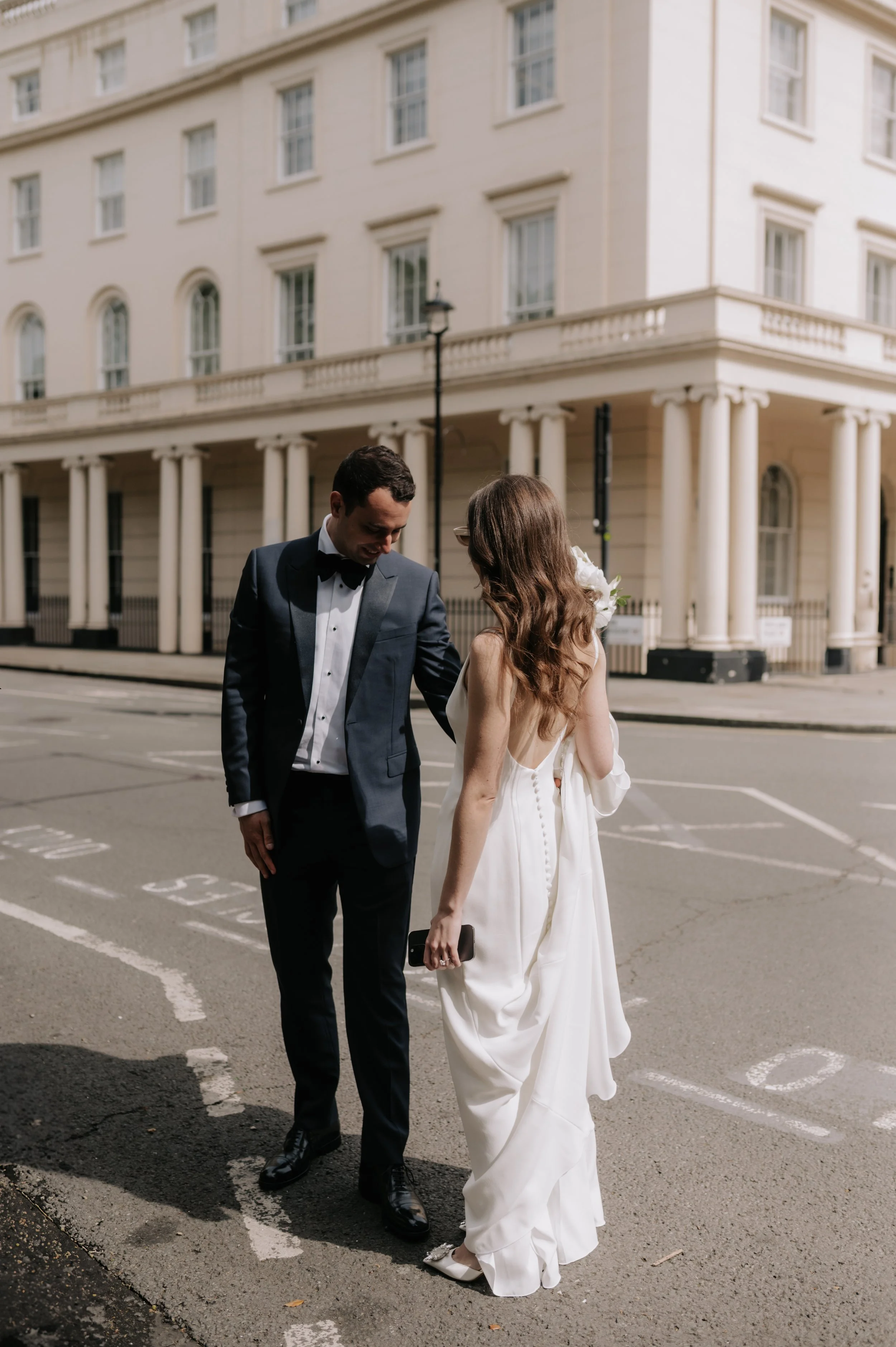 London wedding photography at Marylebone Town Hall groom looking at brides dress
